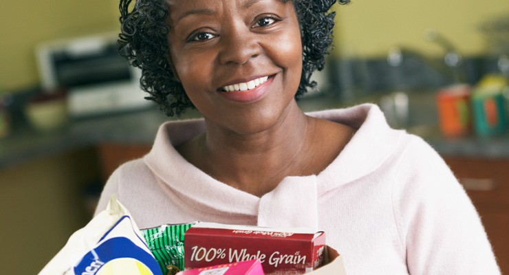 0199_74579864 woman holding a bag of groceries in the kitchen