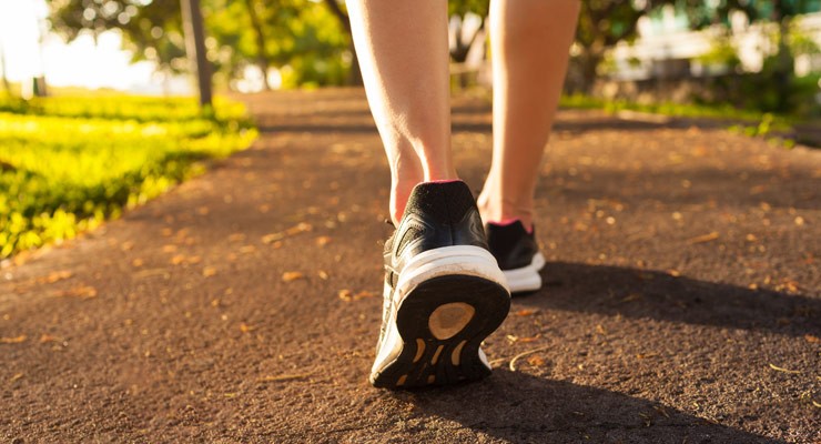 image of woman's lower legs in sneakers, walking away