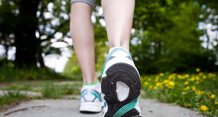 image of woman's lower legs in sneakers, walking away